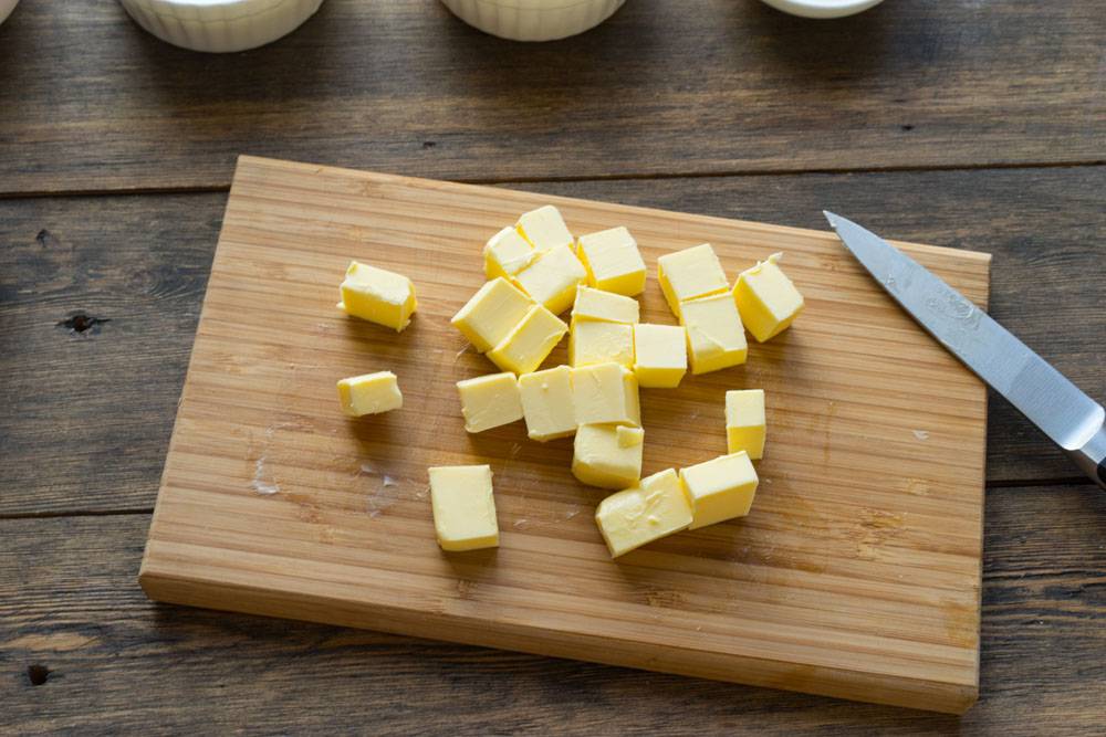 Орехи и сливочное масло. Масло нарезанное кубиками. Свежее сливочное масло разрезанное на кубики. Масло порезать кубиками. Резать масло кубиками\.